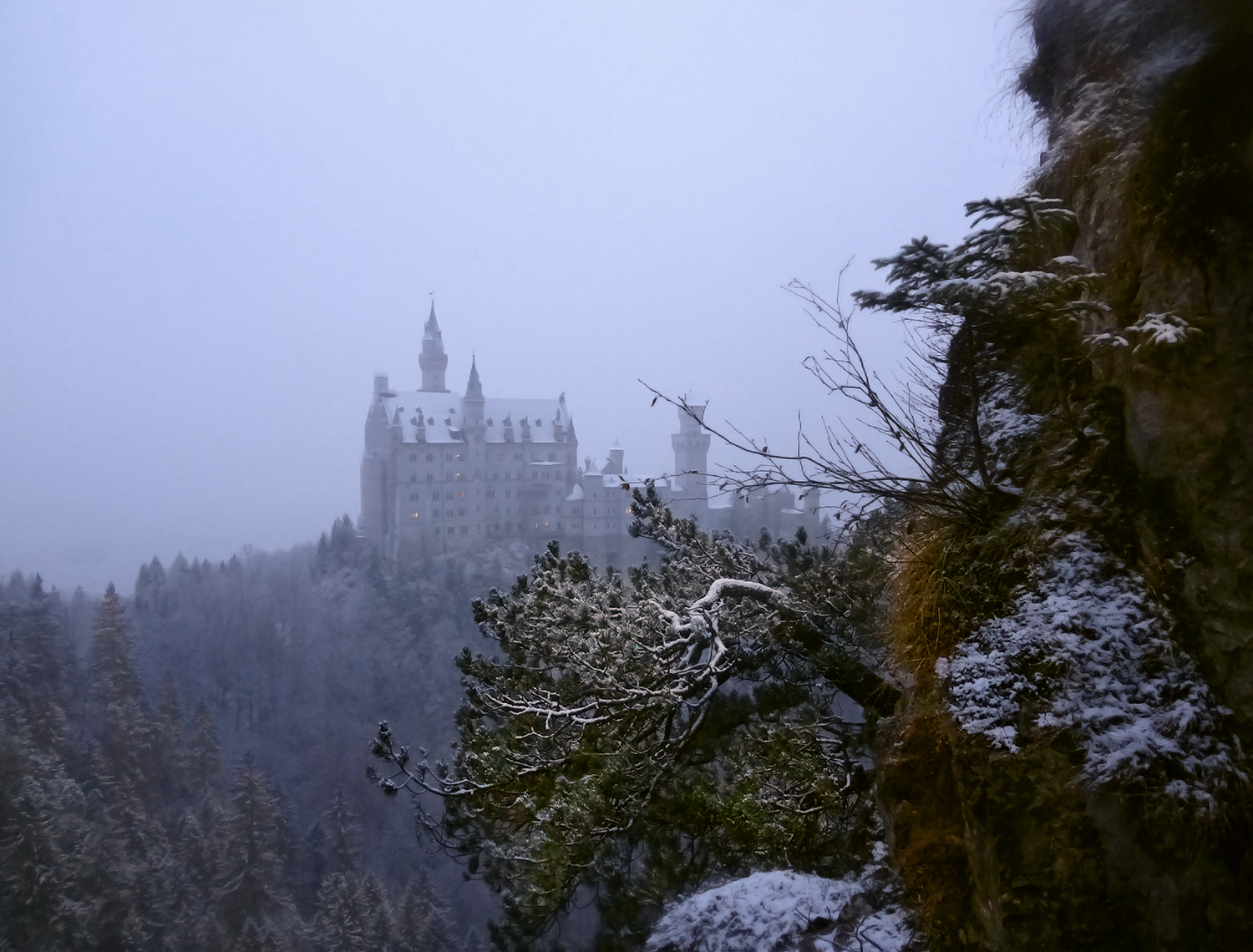 Early morning. Sleepy Neuschwanstein Castle in fog and snow. Bavaria, Germany.